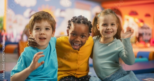 Portrait of Happy Diverse Children Sitting on a Floor and Posing Together in a Modern Kindergarten. Beautiful International Small Kids Looking at Camera, Smiling