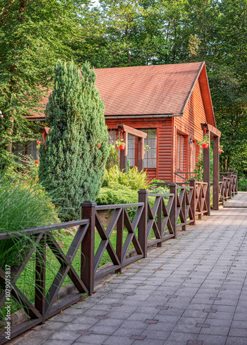 Obraz na płótnie Wooden house in green forest in summer day. w salonie