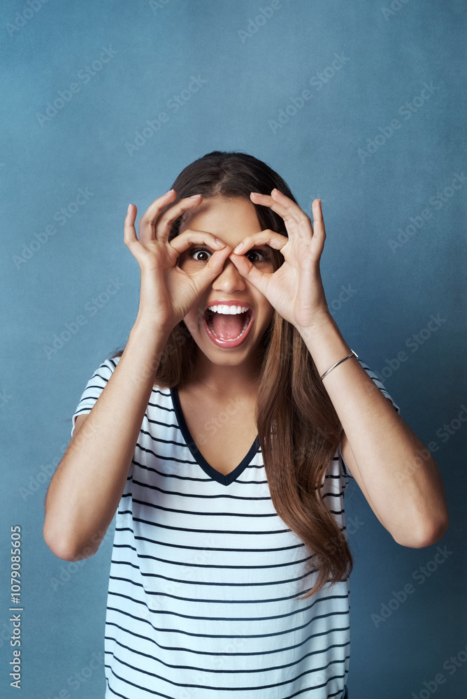 Woman, binocular hands and eyes in studio portrait for comic, funny face and smile for casual fashion. Gen z model, ok hand gesture and crazy, screaming and positive mindset on gray background Woman, binocular hands and eyes in studio portrait for comic, funny face and smile for casual fashion. Gen z model, ok hand gesture and crazy, screaming and positive mindset on gray background