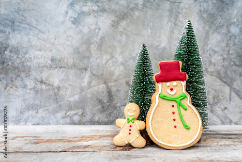 Merry Christmas Cookie Gingerbread man and Snowman easy minimal style with a mini christmas tree on wooden table with snow atmosphere winter background and copy space. photo