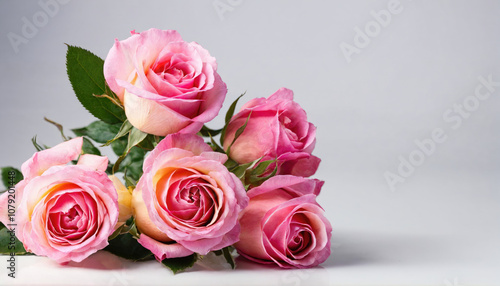 A bouquet of pink roses lies on a white surface