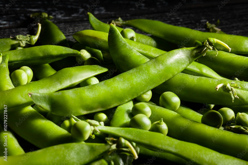 green peas on black wood background green peas on black wood background