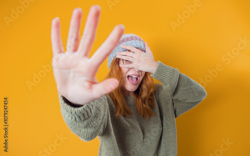 Don't come in any closer. Woman covering face and eyes with hand. Gesture with fear face expression, isolated on white background