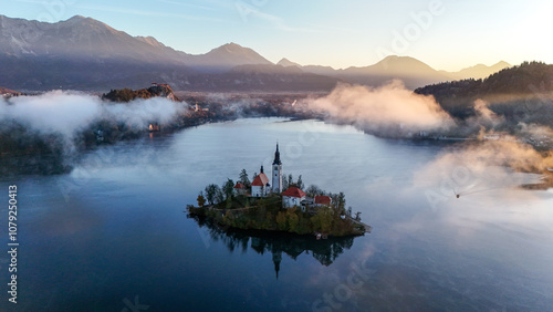 Bled lake in the morning. Aerial morning view of church of Assumption of Maria on Bled lake. Foggy autumn sunrise in Julian Alps, Slovenia, Europe.