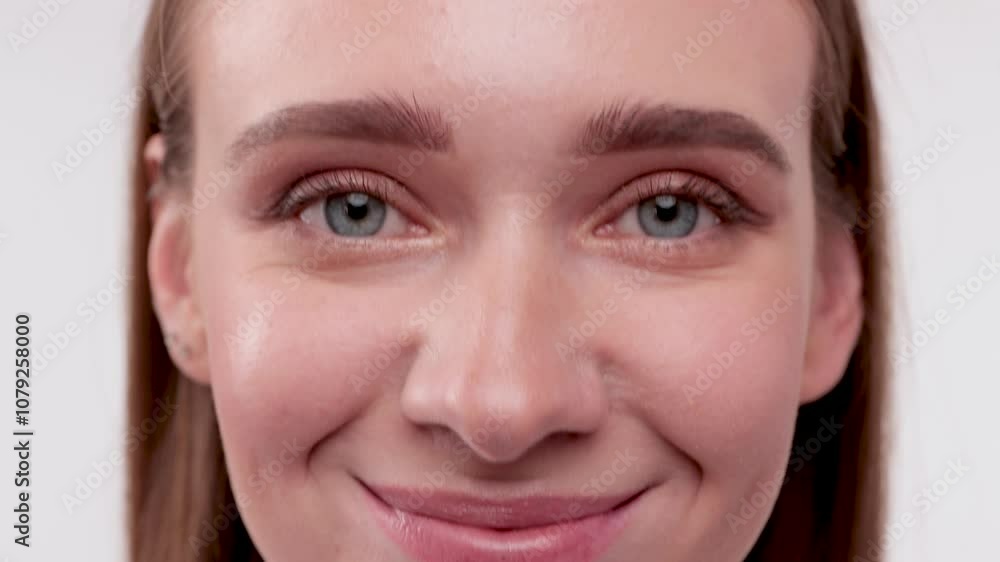 Portrait of attractive girl with healthy clean skin and beautiful make-up. Aesthetic cosmetology and makeup concept.She holds a flower near her face Portrait of attractive girl with healthy clean skin and beautiful make-up. Aesthetic cosmetology and makeup concept.She holds a flower near her face