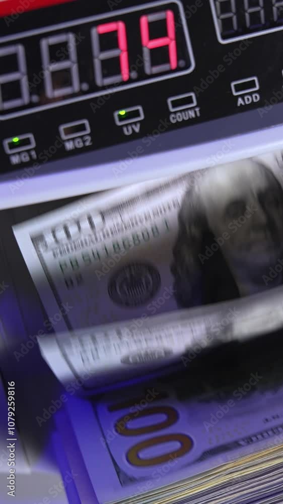Electronic operations for counting paper money. Cash money counting machine. Banknote counter are counting one hundred dollar bills. Top view. Close-up. Vertical video Electronic operations for counting paper money. Cash money counting machine. Banknote counter are counting one hundred dollar bills. Top view. Close-up. Vertical video