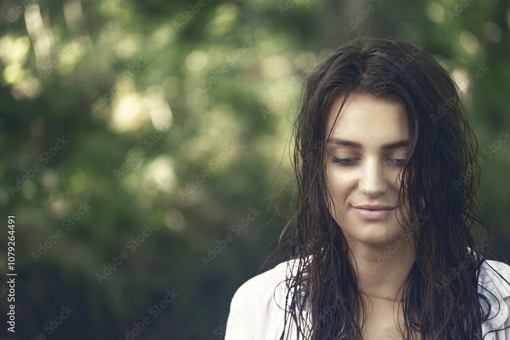 Naklejka premium Smiling attractive girl with wet long hair is posing outdoors. Edited as a cinematic photo. Horizontally. 