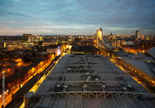 Aerial view looking over roof of the Gmex conference centre and skyline of Manchester at dusk photo