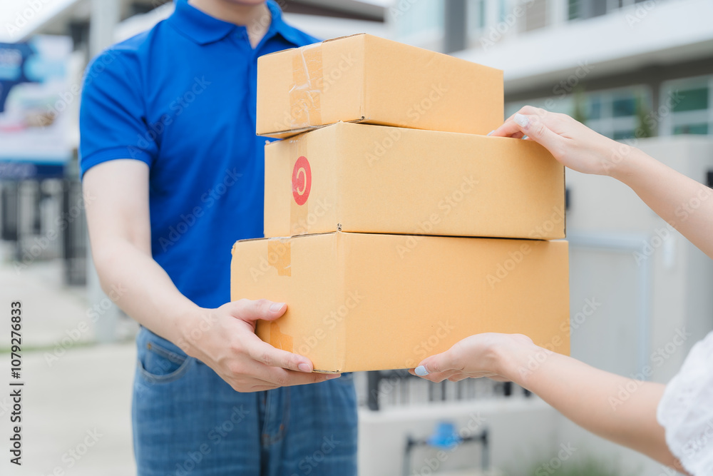 Delivery Confirmation: A courier in a blue polo shirt carefully hands over a stack of cardboard boxes to a customer, signifying a successful delivery and customer satisfaction. Delivery Confirmation: A courier in a blue polo shirt carefully hands over a stack of cardboard boxes to a customer, signifying a successful delivery and customer satisfaction.