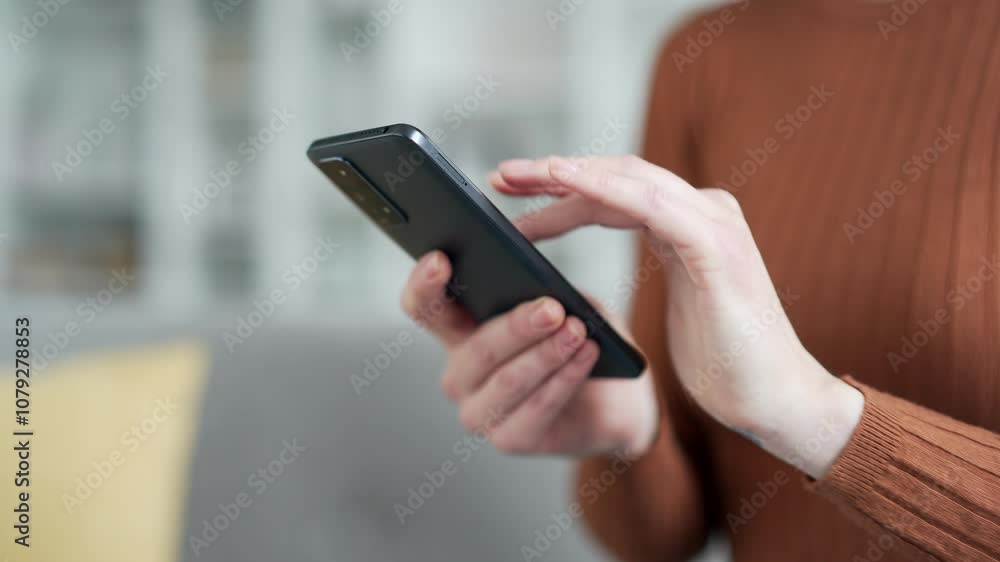 Close up of female hands interacting with phone in modern living room. Young adult woman engaged in digital communication, browsing or social media. Concept of technology usage, lifestyle, connection Close up of female hands interacting with phone in modern living room. Young adult woman engaged in digital communication, browsing or social media. Concept of technology usage, lifestyle, connection