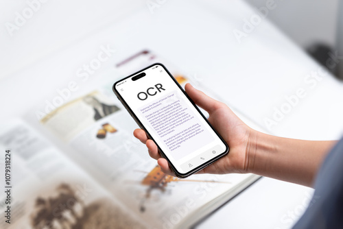 Smartphone with OCR app instantly scanning and digitizing book text, symbolizing modern technology's ability to bring printed words to life through real-time text recognition