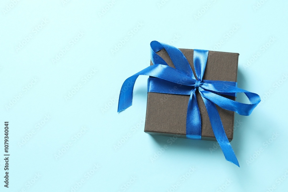 Beautiful gift box tied with bow on color background Beautiful gift box tied with bow on color background