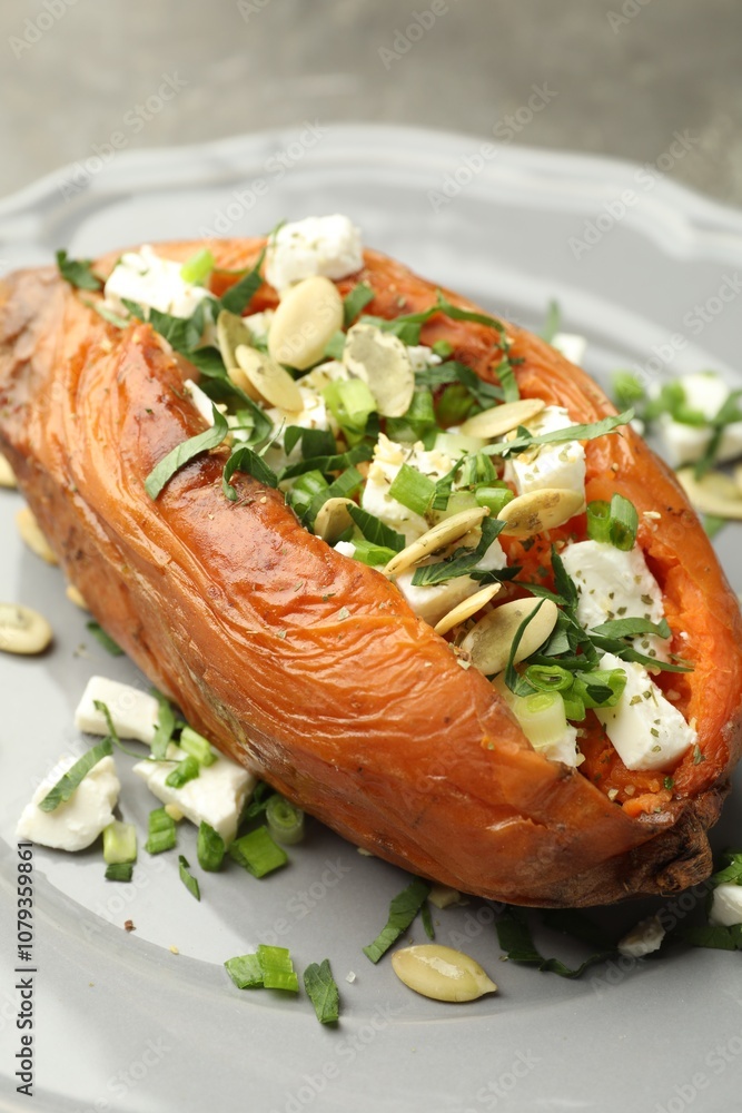 Tasty cooked sweet potato with feta cheese, pumpkin seeds and green onion on table, closeup Tasty cooked sweet potato with feta cheese, pumpkin seeds and green onion on table, closeup