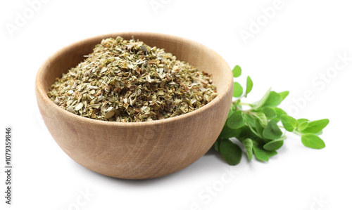 Dried oregano in bowl and green leaves isolated on white