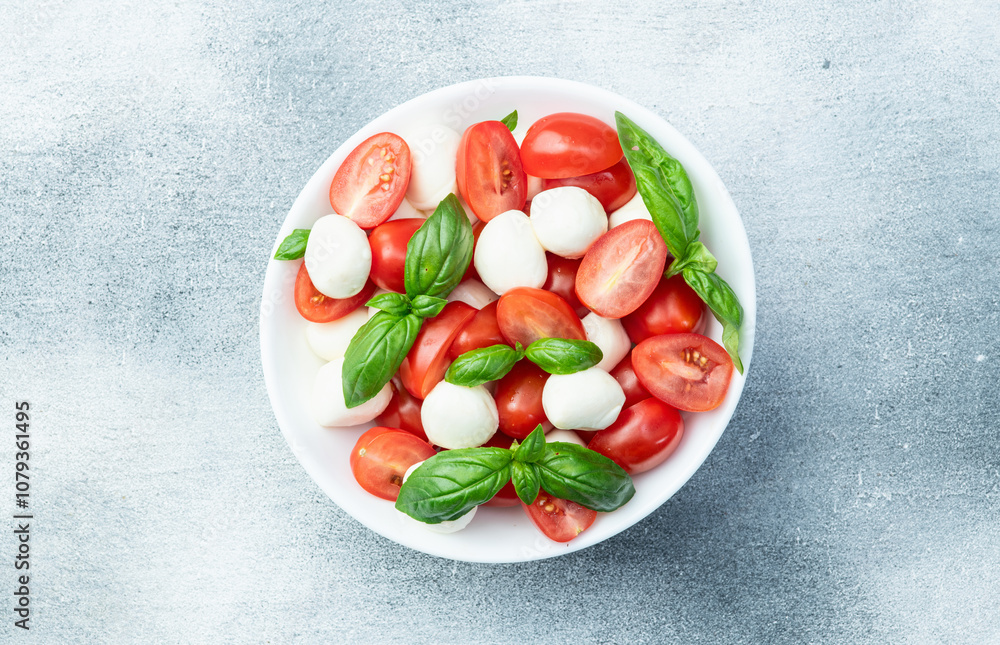 Basil leaves , cherry tomatoes and mozzarella cheese . In bowl food photography Basil leaves , cherry tomatoes and mozzarella cheese . In bowl food photography