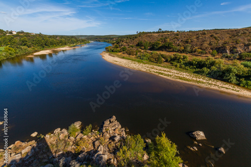 winding river bordered by sandy banks and lush vegetation