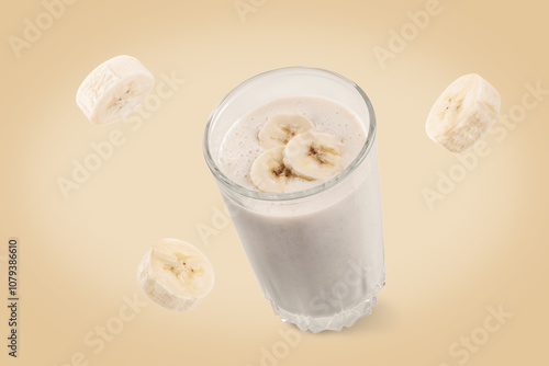 Banana milkshake with flying banana slices on a yellow background