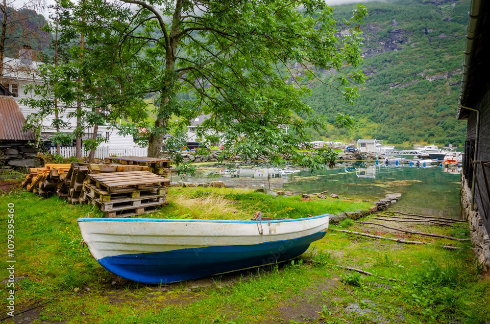 Boat on the coast of Geirangerfjord in town Geiranger, one of the most beautiful fjords in Norway