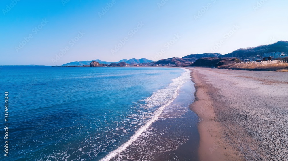 Scenic Coastal Beach Landscape with Gentle Waves and Distant Hills Under Clear Sky Scenic Coastal Beach Landscape with Gentle Waves and Distant Hills Under Clear Sky