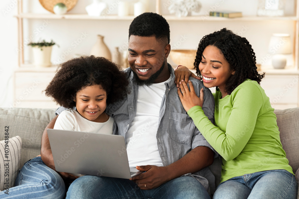 Fototapeta premium Loving African American Family Of Three Resting On Couch With Laptop, Spending Quarantine Time At Home Together, Surfing Internet Or Watching Movies