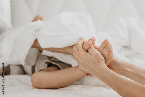 Child Relaxing Under a Blanket with Feet Poking Out