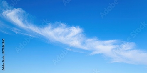 Fototapeta Naklejka Na Ścianę i Meble -  A tranquil blue sky with a few wispy stratus clouds stretching across the horizon, subtle, day, muted
