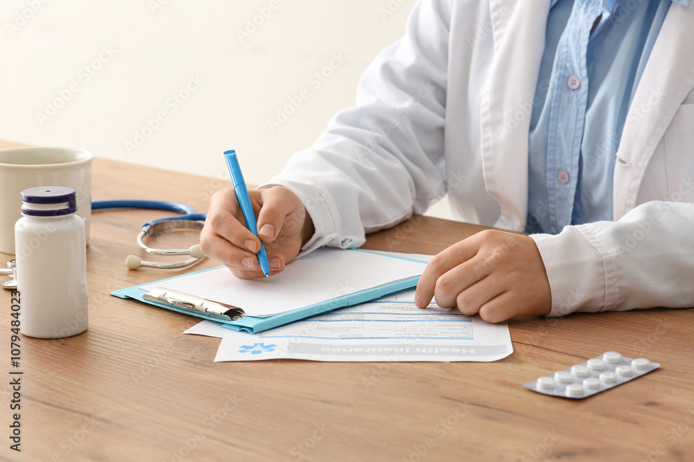 Male doctor writing on clipboard near stethoscope and pills at wooden table Male doctor writing on clipboard near stethoscope and pills at wooden table