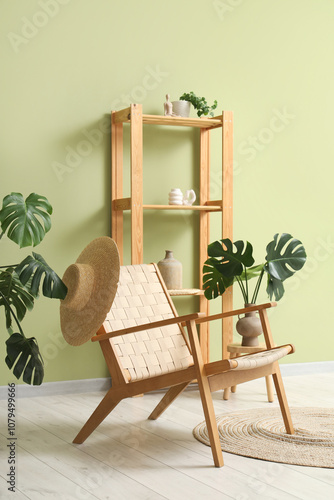 Wicker armchair with monstera leaves in living room