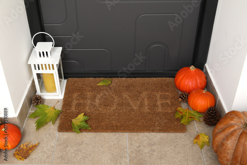 Bild auf Leinwand Doormat with lantern, pumpkins and autumn leaves in hallway