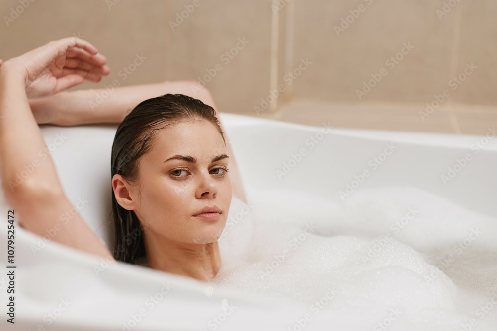 Relaxed young woman enjoying a bubble bath at home, with a serene expression and water bubbles around her. Self-care and relaxation concept. Relaxed young woman enjoying a bubble bath at home, with a serene expression and water bubbles around her. Self-care and relaxation concept.