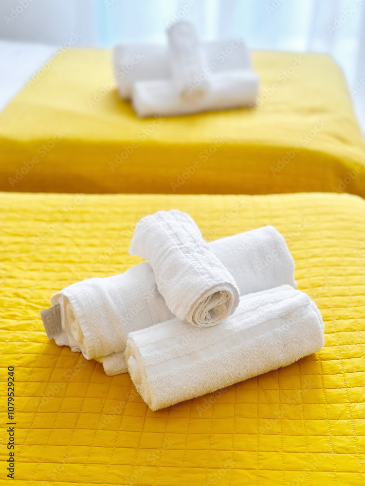 Clean Fresh Fluffy White Towels on Yellow Bed in Hotel Apartments Clean Fresh Fluffy White Towels on Yellow Bed in Hotel Apartments