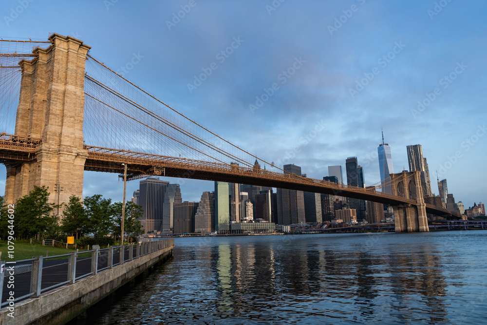 Fototapeta premium Brooklyn bridge to Manhattan. Urban architecture of New York city. Brooklyn bridge of New York city. Brooklyn landmark. Manhattan cityscape with skyscraper architecture. Hudsson river