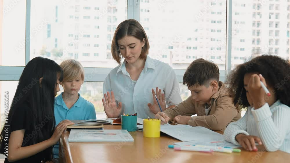 Professional caucasian teacher telling story to diverse student while sitting at table with storybook and colored book. Smart learner listening story while colored picture from instructor. Erudition. Professional caucasian teacher telling story to diverse student while sitting at table with storybook and colored book. Smart learner listening story while colored picture from instructor. Erudition.