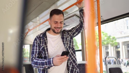 Young man riding in a city bus and using his smartphone