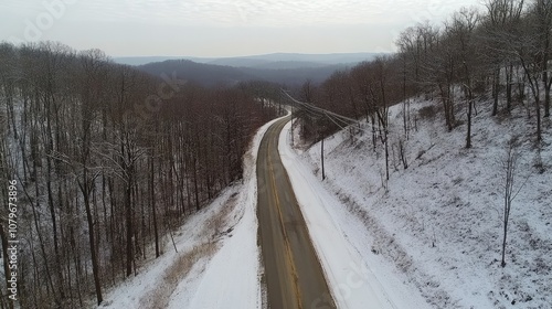 Serene Aerial View of Winding Country Road Surrounded by Snow-Covered Trees and Hills Under a Cloudy Sky in Winter Landscape