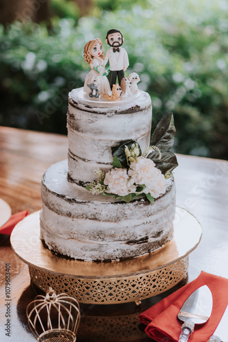 Wedding cake with couple and their puppies on top photo