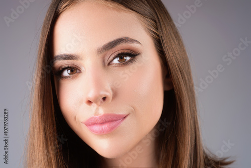 Close-up portrait of lovely pretty girl isolated over studio background. Beauty woman with perfect skin. Makeup and cosmetics. Natural makeup for beauty salon. Care cosmetics, face and body skin care.