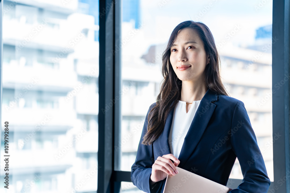 外を見つめるスーツを着た女性 外を見つめるスーツを着た女性