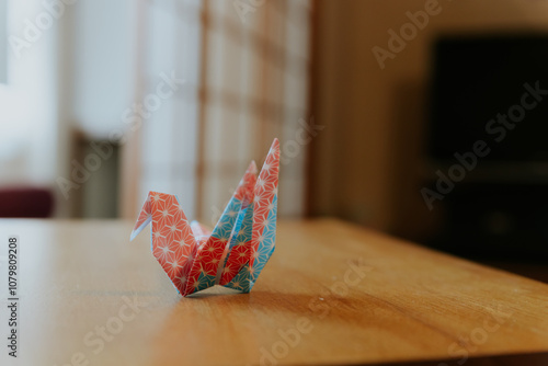 blue red and white origami, tsuru bird paper art on wooden table, japanese style decoration photo