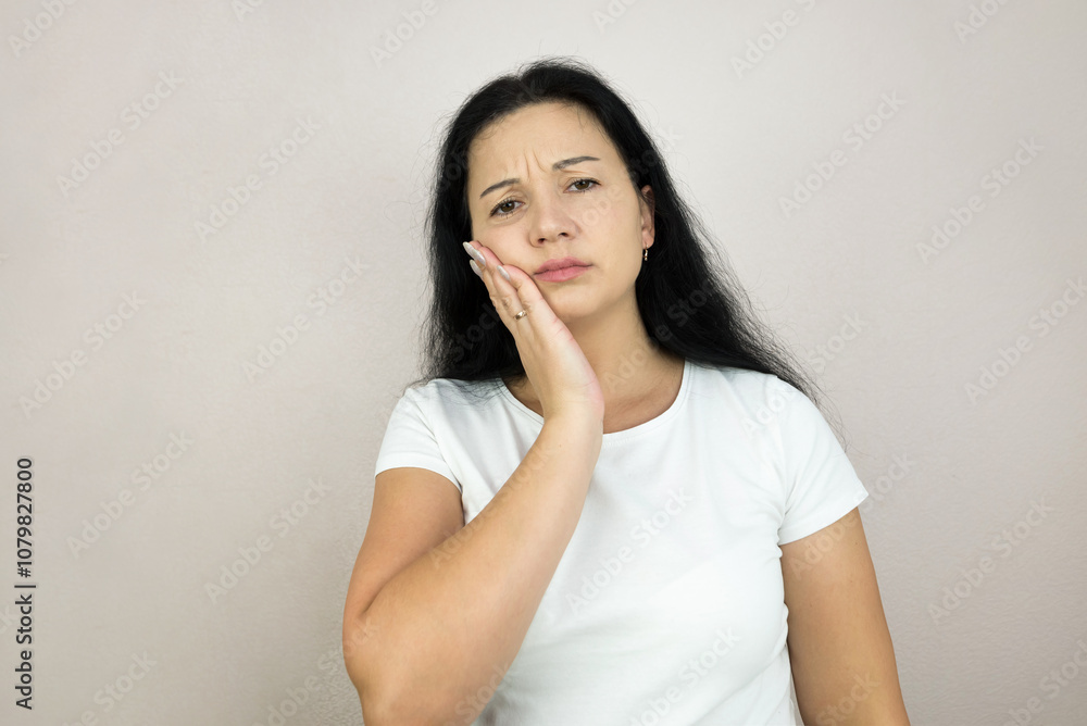 Beautiful young woman suffering from toothache on gray background Beautiful young woman suffering from toothache on gray background