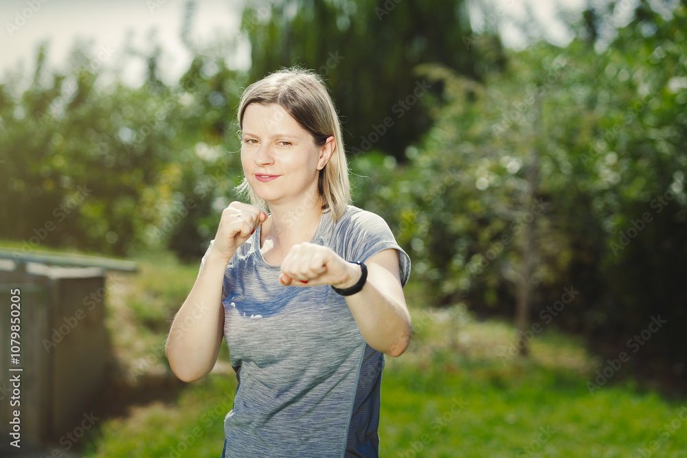 Young woman boxing in park, confident female fights back all problems Young woman boxing in park, confident female fights back all problems