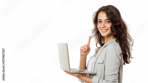 Cheerful young woman holding laptop and pointing finger sideways on white background