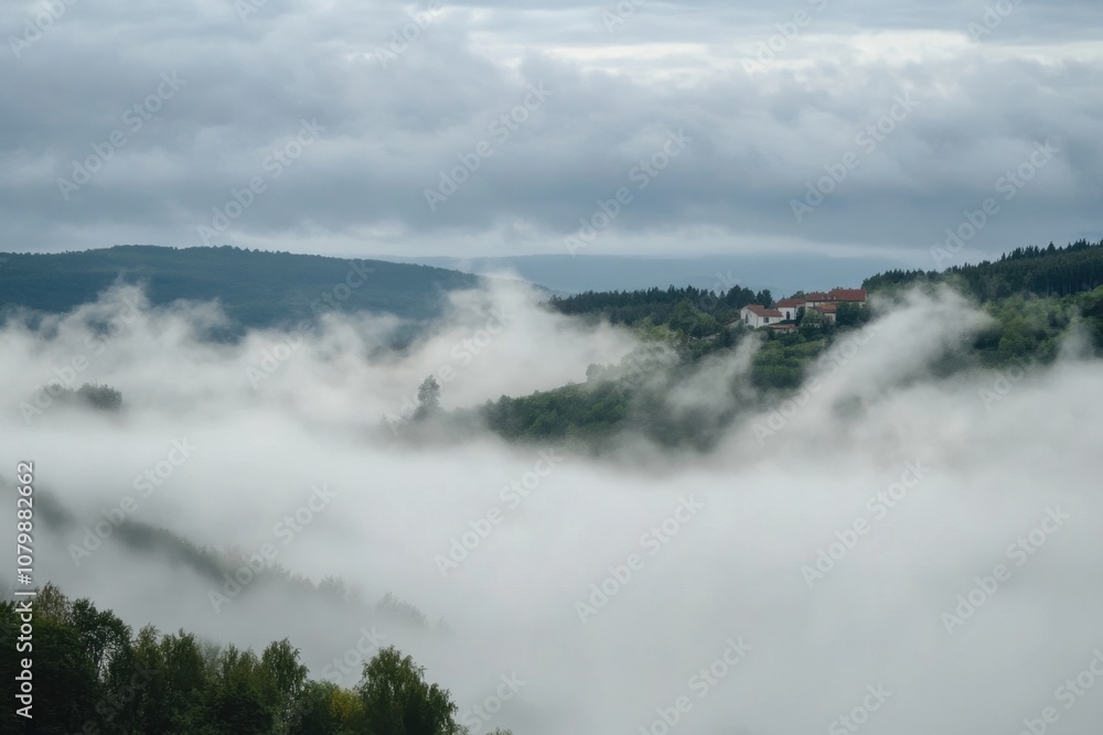 Obraz premium A small village nestled in a valley, shrouded in fog.