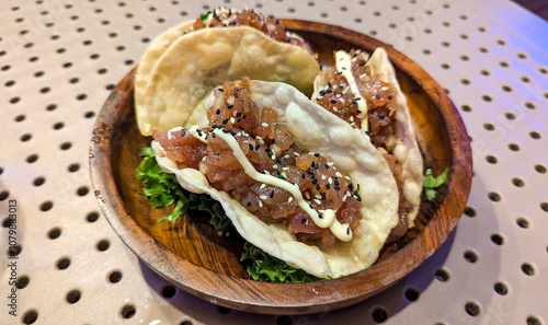 Delicious cuisine of raw tuna poke taco served on a wooden plate on tropical island of Mo'orea in French Polynesia, South Pacific