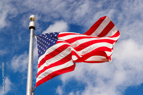 Obraz na plátně American flag waving against a blue sky