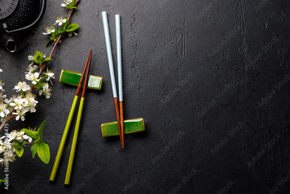 Table adorned with cherry blossom branch and chopsticks, epitomizing Japanese food culture Table adorned with cherry blossom branch and chopsticks, epitomizing Japanese food culture