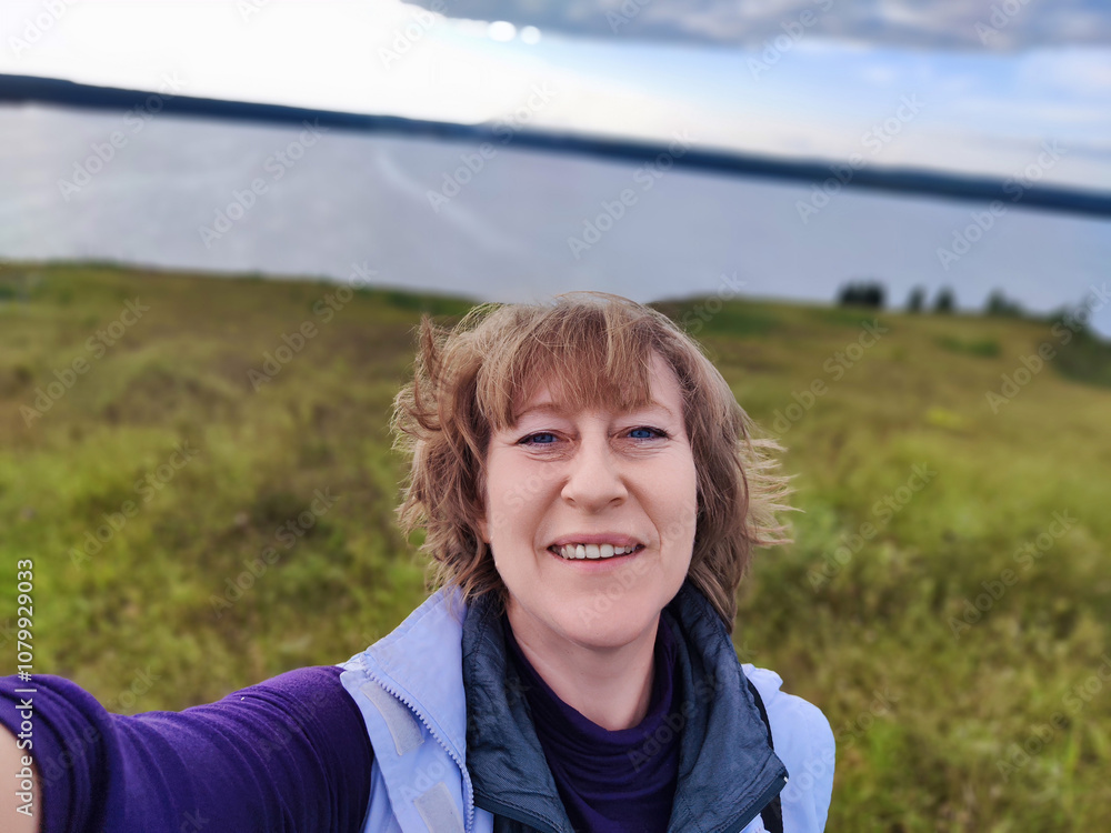 Woman blogger takes a joyful selfie by the serene lakeside during her latest travel adventure in nature Woman blogger takes a joyful selfie by the serene lakeside during her latest travel adventure in nature
