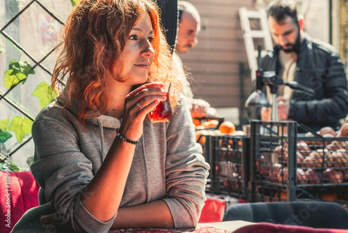 Young pretty woman having turkish tea in the cafe of Istanbul photo