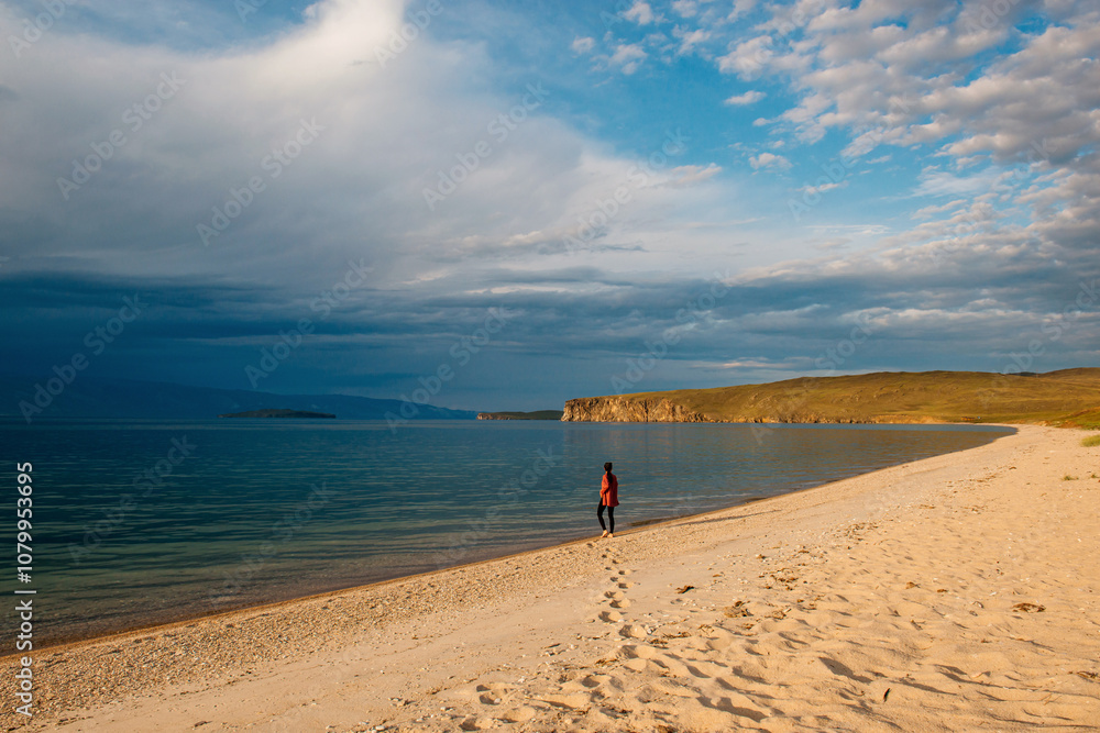Fototapeta premium a girl walks along the shore of Lake Baikal