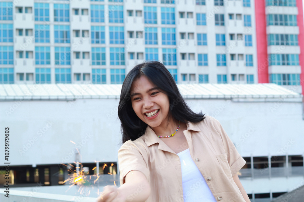 happy asian young woman holding sparklers celebrate new year eve in outdoor roof top with city building background happy asian young woman holding sparklers celebrate new year eve in outdoor roof top with city building background